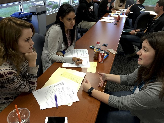 Liz Lewis, right, American Woodmark CFO assistant, discusses FBLA competitive events with Sherando seniors Autumn Gordan and Danielle Mudd. Rachel Mahoney/Daily